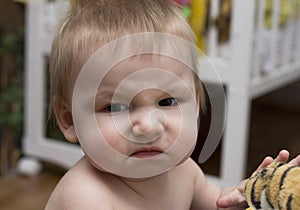 Portrait of a baby with disgust facial expression photo