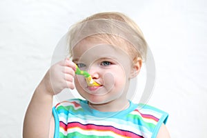 Portrait of baby eating porridge with spoon