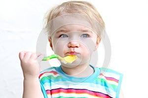 Portrait of baby eating porridge with spoon
