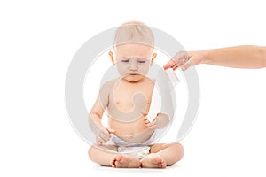 Portrait of a baby getting a diaper change: mom wiping baby`s bottom with baby wipe isolated on a white background. concept