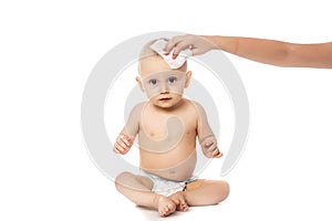 Portrait of a baby getting a diaper change: mom wiping baby`s bottom with baby wipe isolated on a white background. concept