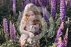 Portrait of a baby girl with a doll. Holidays and trips with family out of town on nature.