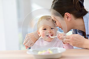 Portrait of baby girl eating lunch with her mother
