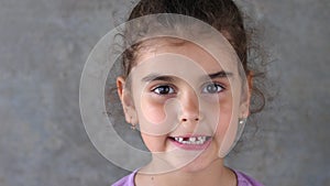 Portrait of a baby girl with a toothless smile. A beautiful girl with a crooked tooth falling out. To show the absence