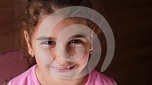 Portrait of a baby girl with a toothless smile. The child laughs hard. Show no teeth.