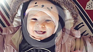 Portrait of baby girl in winter jacket and hat smiling on christmas background outfit fashion clothes