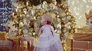 Portrait of a baby infront of Christmas tree playing with a New Year's toy