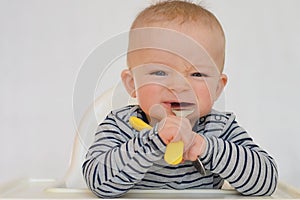 Portrait of baby learning to eat with fork and spoon