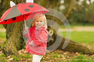 Portrait of baby with red umbrella outdoors