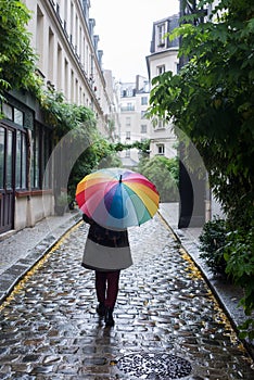 Eine Frau straßen Regenbogen ein Regenschirm 