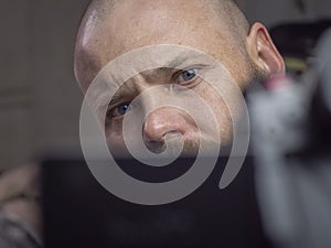 Portrait of a bald man with a beard with beautiful blue eyes, looking away from the camera. man makes selfie