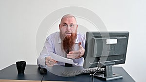 Portrait of a bald man at a desk looking at a report and cursing. The dissatisfied boss dismisses the subordinate.