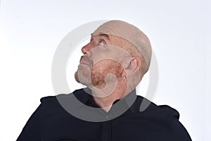 Portrait of a bald man looking up on white photo