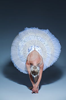 Portrait of the ballerina in ballet tatu on blue background