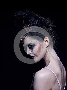 Portrait of the ballerina in the role of a black swan on black background