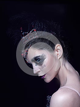 Portrait of the ballerina in the role of a black swan on black background