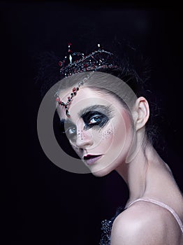 Portrait of the ballerina in the role of a black swan on black background