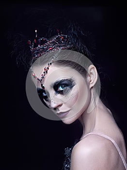 Portrait of the ballerina in the role of a black swan on black background