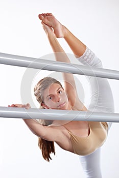 Portrait, ballet and girl stretching legs on barre in classroom, practice and student exercise. Ballerina, flexibility