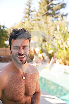 Portrait Of Bare Chested Hispanic Man Outdoors With Friends Enjoying Summer Pool Party