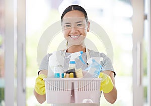 Portrait, basket and cleaning with a woman housekeeper using products to remove bacteria in a home. Safety, smile and