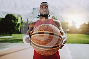 Portrait of a basketball player holding ball with hands - Athlete concentrating on game