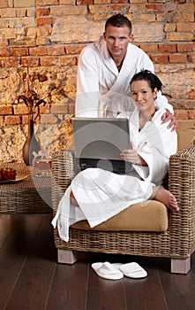 Portrait of bathrobe couple with laptop