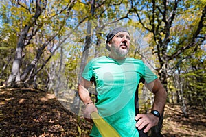 Portrait of a bearded athletic man engaged in slack next to a stretched sling for balance in the autumn forest. athlete