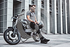 Portrait of bearded biker chilling with his motorbike