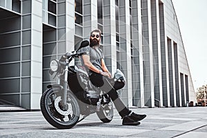 Portrait of bearded biker chilling with his motorbike