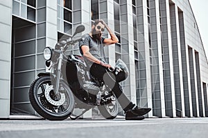 Portrait of bearded biker chilling with his motorbike