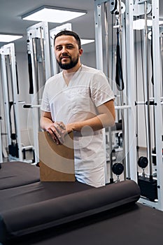 Portrait of bearded caucasian doctor with clipboard in hands.Serious confident professional masseur