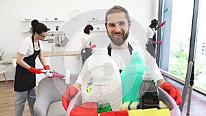 Portrait of bearded Caucasian man cleaning worker holding bucket with detergents