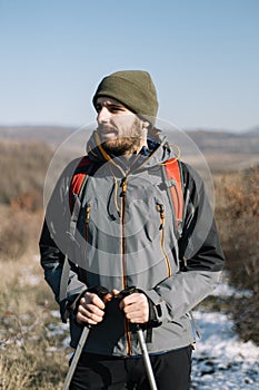 Portrait of a bearded hiker standing on field path