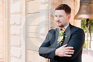 Portrait of a bearded hipper groom in a blue suit and a red tie at a wedding walk photo