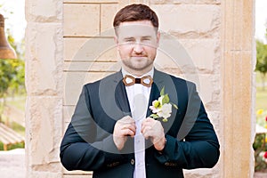 Portrait of a bearded hipper groom in a blue suit and a red tie at a wedding walk photo