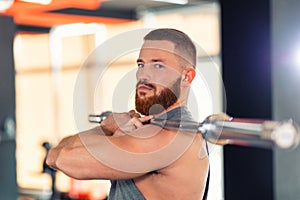 Portrait of a bearded man holding a barbell. Sports concept