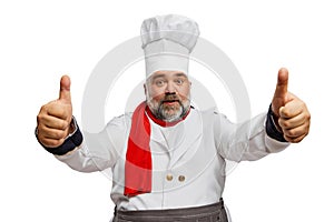 Portrait of bearded man, restaurant chef in uniform posing, showing positive gesture with fingers isolated on white