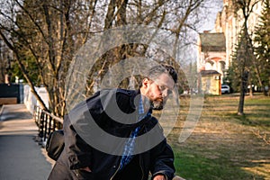 Portrait of a bearded middle-aged man against the background of a Christian monastery