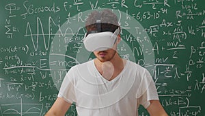 Portrait of bearded teacher wearing virtual reality headset in school classroom