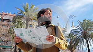 Portrait of bearded tourist male reading a map on Barcelona. Caucasian traveler guy sightseeing and searching locations