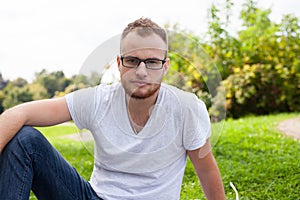 Portrait of bearded young man. Caucasian man smiling happy on sunny summer or spring day outside in park