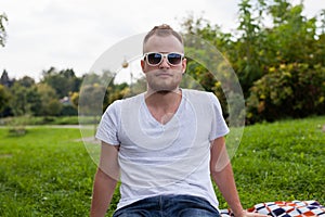 Portrait of bearded young man. Caucasian man smiling happy on sunny summer or spring day outside in park