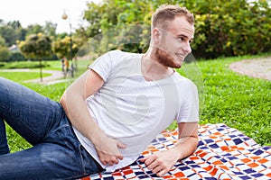 Portrait of bearded young man. Caucasian man smiling happy on sunny summer or spring day outside in park