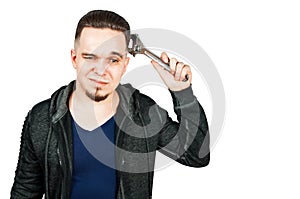 Portrait of bearded young man holding adjustable wrench. isolated on white background