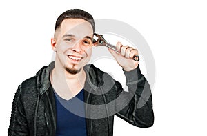 Portrait of bearded young man holding adjustable wrench. isolated on white background