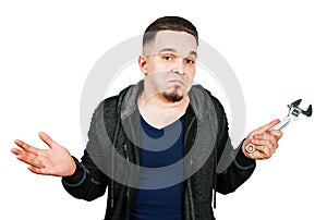 Portrait of bearded young man holding adjustable wrench. isolated on white background