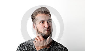 Portrait of a bearded, young and thoughtful man isolated on a white background