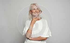 Portrait of a beautiful 50 years woman is smiling, looking up