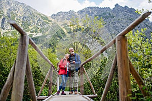 Portrait of beautiful active senior couple hiking together in autumn mountains.